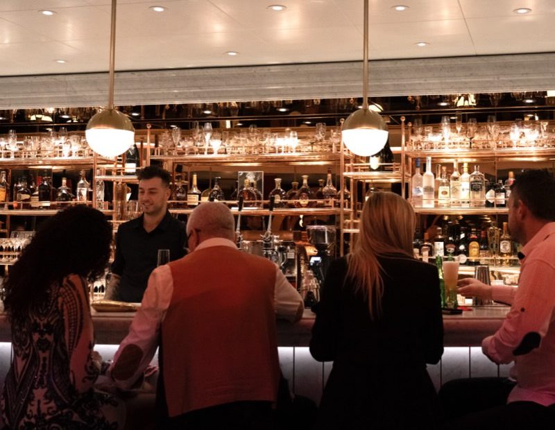 Craft cocktail being served at a bar using bar tab on Virgin Voyages