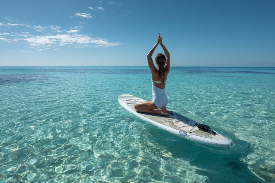 Woman doing SUP yoga on a paddleboard at Bimini Beach Club